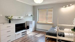 Habitación con 1 dormitorio con 1 cama y TV. en Quiet Base by LibertaRent, en Wałbrzych
