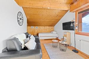ein Wohnzimmer mit Couch und Fernseher in der Unterkunft Superbe studio avec une vue magnifique in Leytron