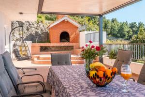 una mesa con un jarrón de fruta en el patio en Apartments Spalato, en Podstrana