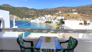 a cup of coffee sitting on a table on a balcony at Blue Port Faros - Sifnos in Faros