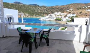 a table and chairs on a balcony with a view of the water at Blue Port Faros - Sifnos in Faros +22 photos