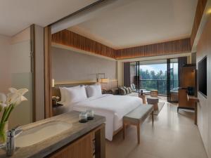 ein Hotelzimmer mit einem Bett und einem Badezimmer in der Unterkunft Novotel Bali Ubud Resort in Payangan