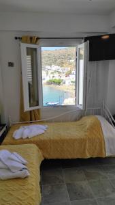 a bedroom with a window with a view of the ocean at Blue Port Faros - Sifnos in Faros