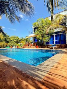 a swimming pool in front of a building at One Bed with AC, Gazebo and Pool in Diani in Ukunda Airport