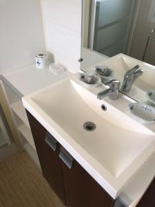 a bathroom with a white sink and a mirror at Domaine des Iscles mobile home clim, jardinet sans vis-à-vis in La Roque-dʼAnthéron