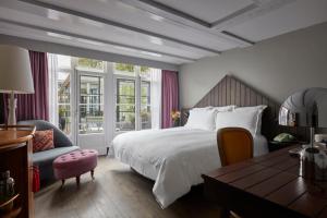 a bedroom with a bed and a desk and a chair at Pulitzer Amsterdam in Amsterdam