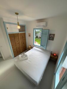 ein Schlafzimmer mit einem großen Bett mit Fenster in der Unterkunft Casa con vistas al mar y jardín in Canet de Mar + 31 Fotos