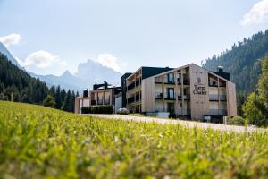 a building on a road with mountains in the background at Turmchalet Adults Only in Braies