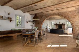 a dining room with a brick wall and a table and chairs at Casale delle Mele by PosarelliVillas in I Pieracci