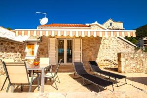 Dubas Studio Apartment في بول: فناء مع طاولة وكراسي أمام المنزل