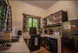 una cocina con fregadero y estufa horno superior en Gold villa2, en Diani Beach