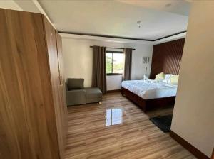 a bedroom with a bed and a couch and a window at WENNROD Hotel in Batangas City