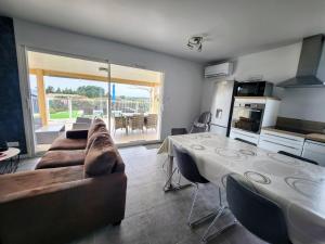 ジョワイユーズにあるEn Ardèche, maison de vacances L'Odalys climatisée avec sa piscine privée et chaufféeのテーブルとソファのあるリビングルーム +20枚の写真