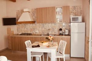 a kitchen with a white table and a white refrigerator at Villa Susca - villa sul mare in Monopoli