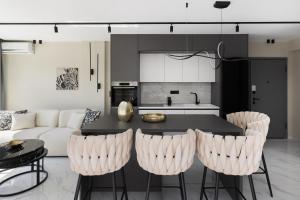 a kitchen and living room with a table and chairs at Ophelia Apartments by halu!, Luxury Apt with Hot Tub in Thessaloniki