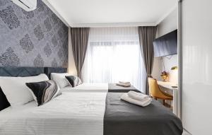 una camera d'albergo con due letti e una scrivania di Villa Tria Quercus with Rooftop Pool a Vodice