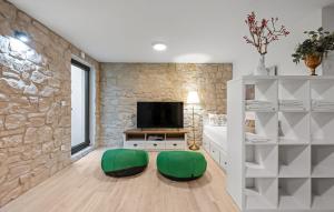 un soggiorno con 2 sedie verdi di fronte a un muro di pietra di Villa Tria Quercus with Rooftop Pool a Vodice Altre 44 foto