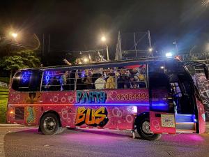 a pink bus with people sitting on the top at Mao's Party Experiment in Bogotá