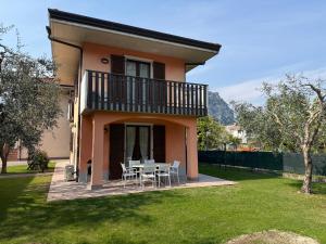 a house with a table and chairs in a yard at Villetta Martinelli in Nago-Torbole