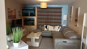 a living room with a couch and a table at Spacious Cheltenham Flat with Free Allocated Parking in Cheltenham