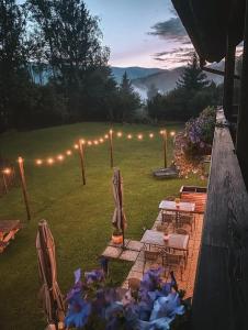 a backyard with chairs and a table and lights at Arriach Apartments in Arriach +99 photos
