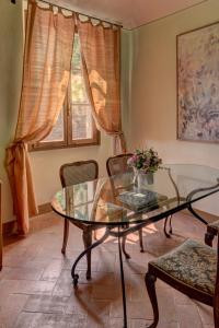 un soggiorno con tavolo e sedie in vetro di Albergo San Lorenzo a Poppi