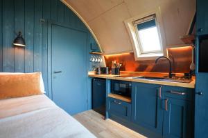 a small kitchen with blue cabinets and a sink at Montrave Estate by Wigwam Holidays in Pitlessie