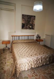 a bedroom with a bed and a painting on the wall at Finestra sui Ponti in Ragusa