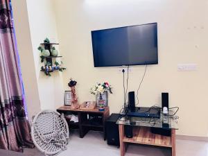 a living room with a flat screen tv on the wall at Paradise Villa in Siliguri