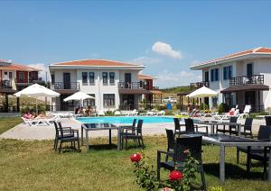 a resort with a pool and tables and chairs at Kalanora Otel in Gelibolu