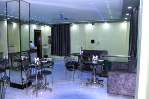 a dining room with black tables and black chairs at Hotel Shobhani in Deoghar