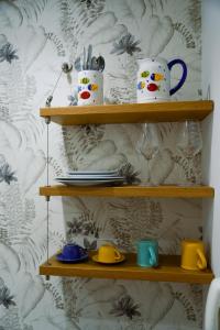 a shelf with cups and dishes on it at Finestra sui Ponti in Ragusa