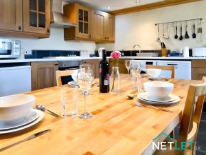 a kitchen with a wooden table with a bottle of wine at Ty Eithin - Rustic Cottage in St Davids in St. Davids +18 photos
