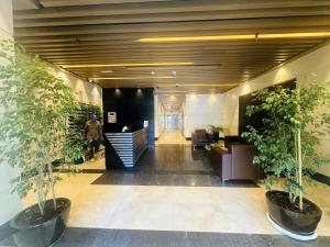 una hall con uffici, piante in vaso e una scala di SUNRISE HOMES - 2 BR with Panoramic Views next to JBR Beach a Dubai Altre 29 foto