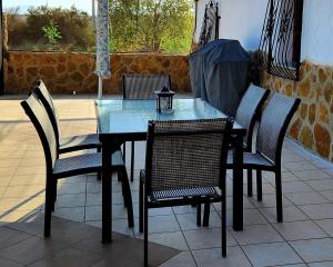 un tavolo in vetro e sedie su un patio di Casita-Max 2Guests-Pool-Patio-Bbq-Parking a Huércal-Overa