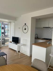 een keuken en woonkamer met een tafel en stoelen bij Beach Suite Leonie Koksijde met zeezicht in Koksijde