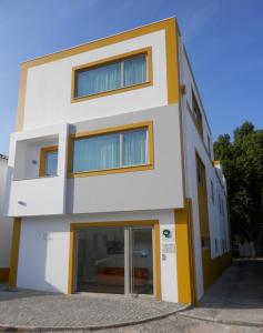 un edificio blanco con toques amarillos en Barquinha River House en Vila Nova da Barquinha