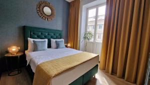 1 dormitorio con 1 cama con cabecero verde y ventana en SLEEPWELL NOWY ŚWIAT - entrance from Ordynacka 14St, through the courtyard, en Varsovia