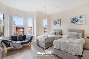 a bedroom with two beds and a couch and windows at Monton Co-living - Private Room Self-cater in Manchester