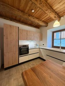 a kitchen with wooden cabinets and a stove top oven at Tabia Apartment in Villagrande