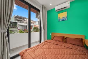 a bedroom with a bed and a green wall at Saluton House in Da Nang