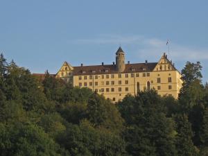 un grand bâtiment au sommet d'une colline plantée d'arbres dans l'établissement Haus Sonntag, à Frickingen
