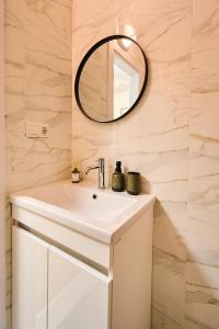 a bathroom with a white sink and a mirror at Smart Stay Valea Crucii Near Botanical Garden in Chişinău