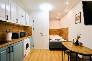 a small kitchen with a table and a bed in a room at Smart Stay Valea Crucii Near Botanical Garden in Chişinău +12 photos