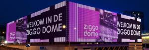 a large building with pink lights on the side of it at Amsterdam Centraal in 10 minutes - nearby metro in Amsterdam