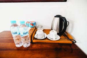 a tray with two bottles of water and a tea kettle at Batur Corner in Kubupenlokan