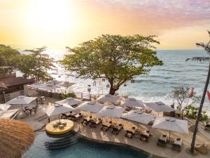an outdoor restaurant with white umbrellas and the ocean at SAii Koh Samui Villas - Adult only 12 plus in Choeng Mon Beach