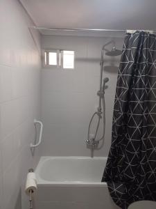 a bathroom with a shower with a black shower curtain at Apartamento AVENIDA in Aguilar de la Frontera +25 photos