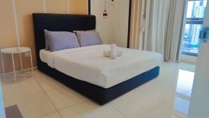 a bedroom with a large bed with purple pillows at The Robertson Bukit Bintang by Wowhome in Kuala Lumpur