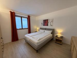 een slaapkamer met een bed, 2 lampen en een raam bij Casa Martinelli in Nago-Torbole